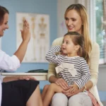 Mãe com criança no colo interagindo com médica representando o engajamento do paciente